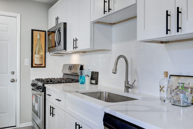 kitchen featuring white cabinets, sink, tasteful backsplash, light stone counters, and stainless steel appliances