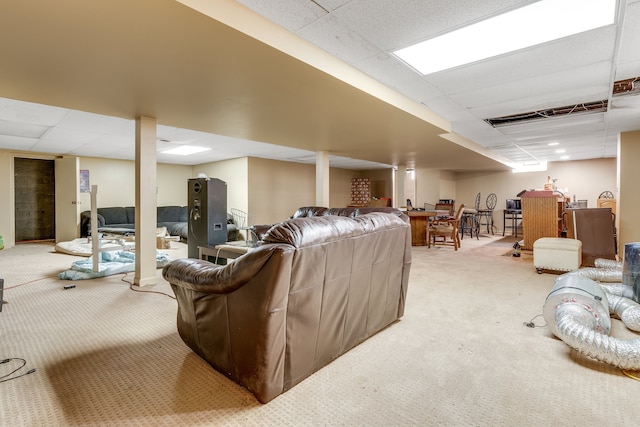 living room with a drop ceiling and light colored carpet