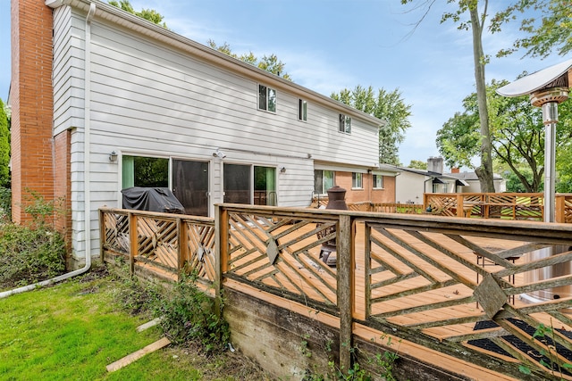 rear view of property featuring a wooden deck