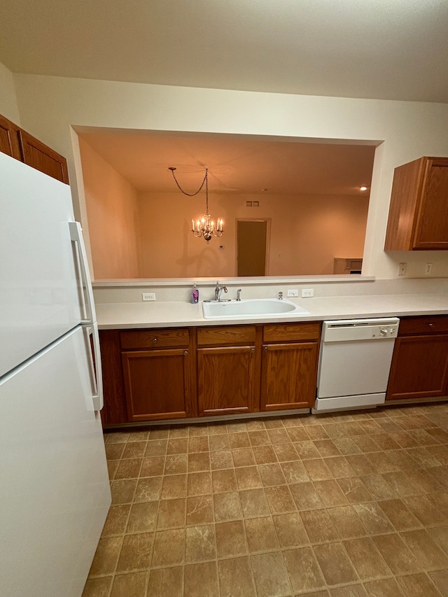 kitchen featuring white appliances, light countertops, a sink, and brown cabinetry