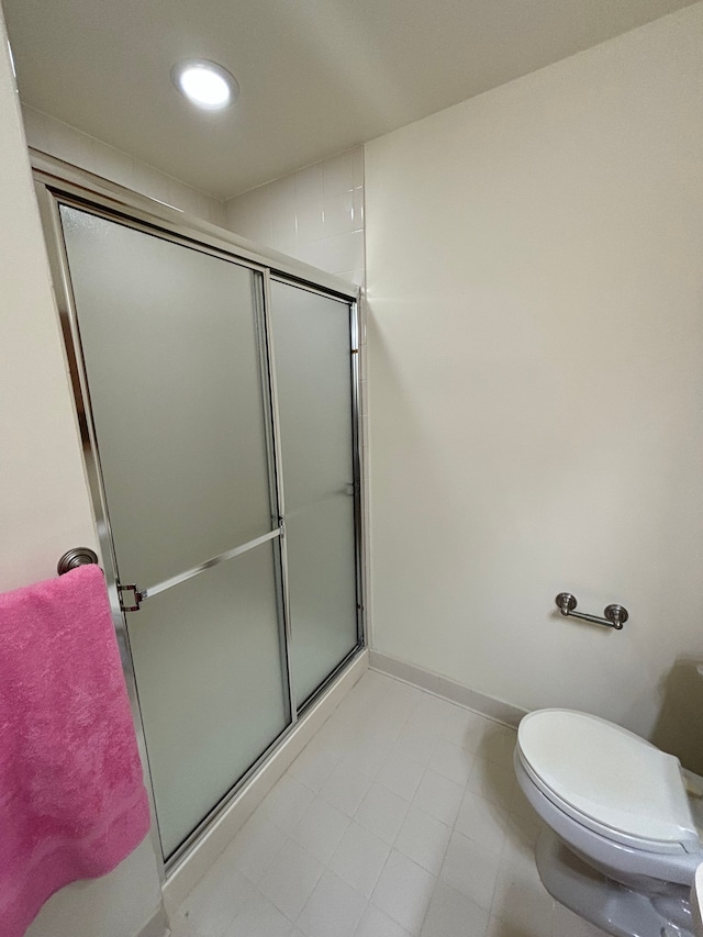 bathroom featuring toilet, recessed lighting, a shower with shower door, and baseboards