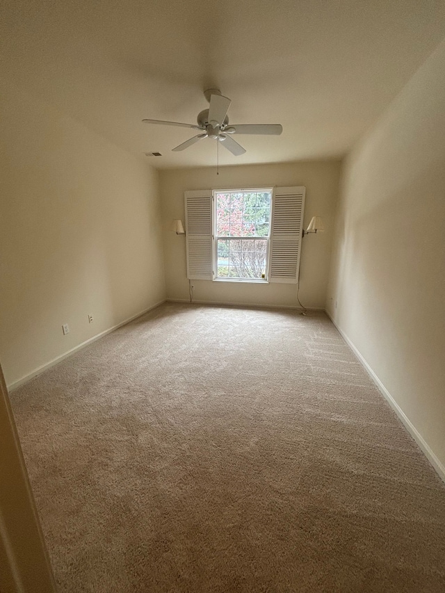 empty room featuring ceiling fan, baseboards, and carpet flooring