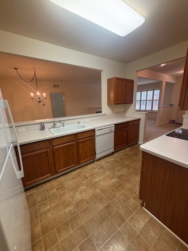 kitchen with dishwasher, light countertops, brown cabinetry, and a sink