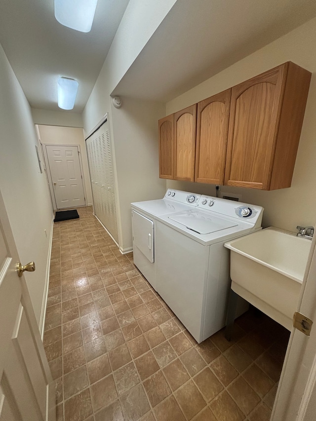 laundry room with washer and dryer, cabinet space, a sink, and baseboards