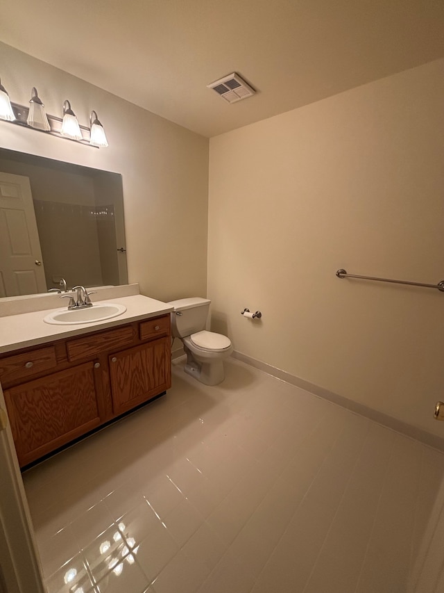 bathroom featuring toilet, baseboards, visible vents, and vanity