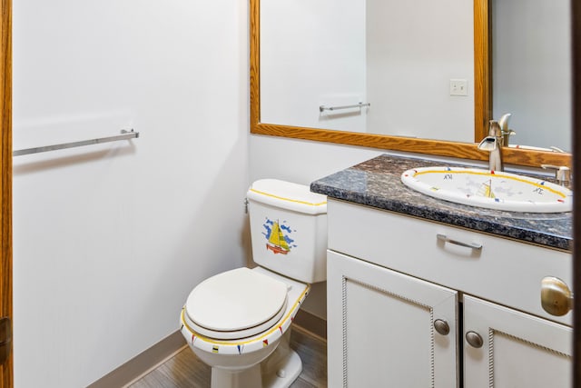 bathroom with toilet, vanity, and hardwood / wood-style flooring