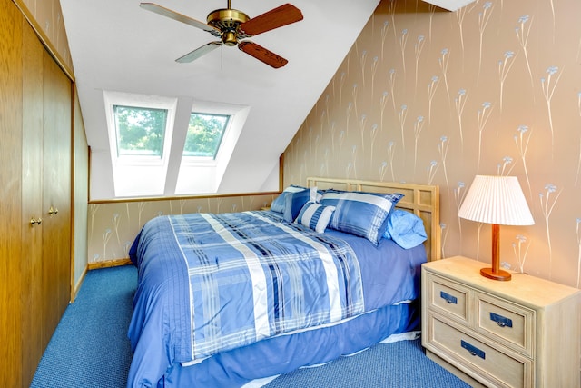 carpeted bedroom with ceiling fan, a closet, and vaulted ceiling with skylight