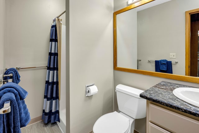 bathroom featuring walk in shower, hardwood / wood-style floors, vanity, and toilet