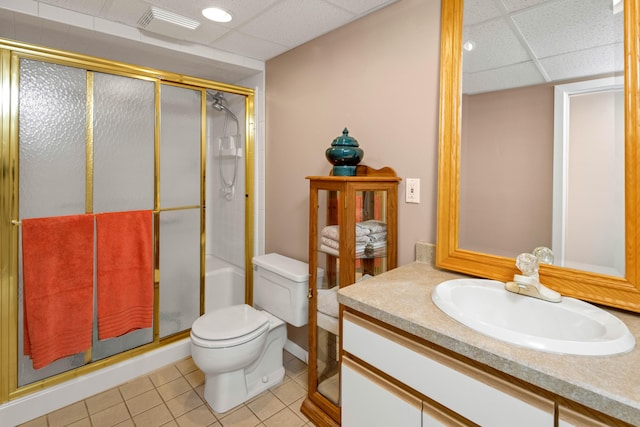 bathroom featuring walk in shower, tile patterned flooring, toilet, a paneled ceiling, and vanity