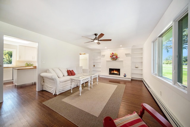 living room with a wealth of natural light, a baseboard heating unit, and dark wood-style flooring