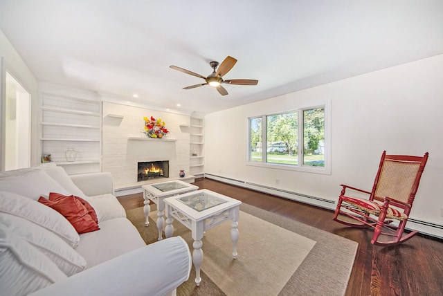 living area with built in features, wood finished floors, recessed lighting, a warm lit fireplace, and ceiling fan