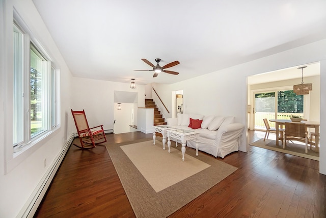 living area featuring dark wood-type flooring, stairway, a ceiling fan, and baseboard heating