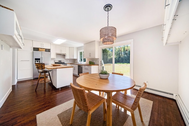 dining area featuring dark wood-type flooring, baseboards, and baseboard heating