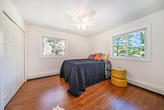 bedroom featuring wood finished floors, baseboard heating, and ceiling fan