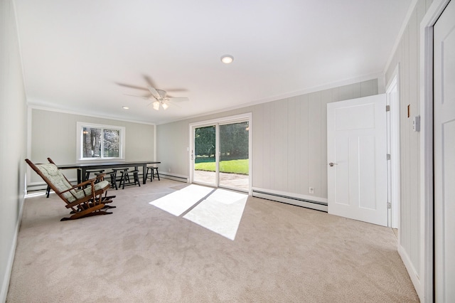 unfurnished room with a baseboard heating unit, crown molding, carpet floors, baseboard heating, and a ceiling fan