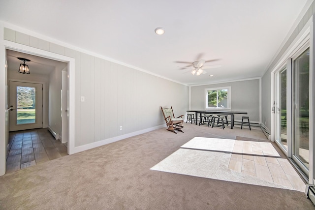 unfurnished room with carpet, baseboards, a ceiling fan, a baseboard heating unit, and crown molding