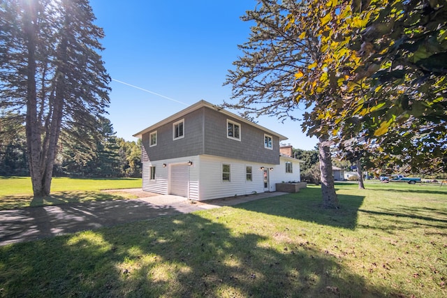 view of side of home with an attached garage, a yard, and driveway