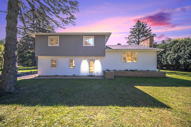 view of front of property featuring a yard and a chimney