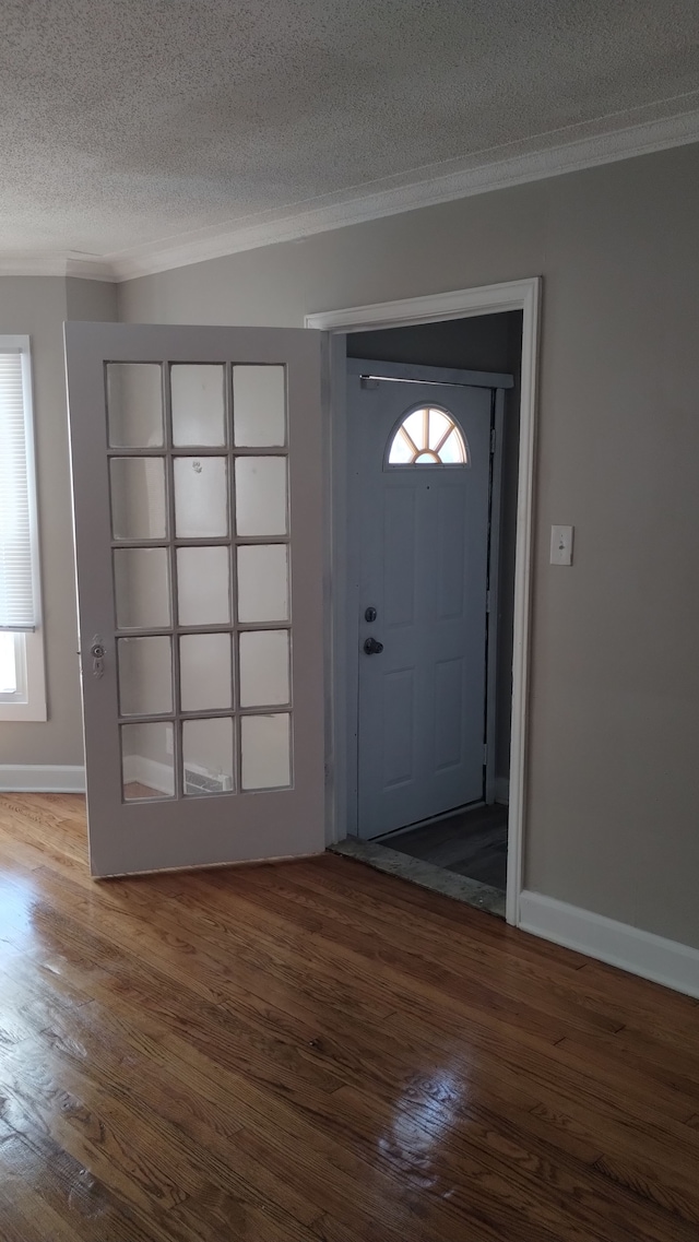 foyer entrance with a textured ceiling and dark hardwood / wood-style flooring