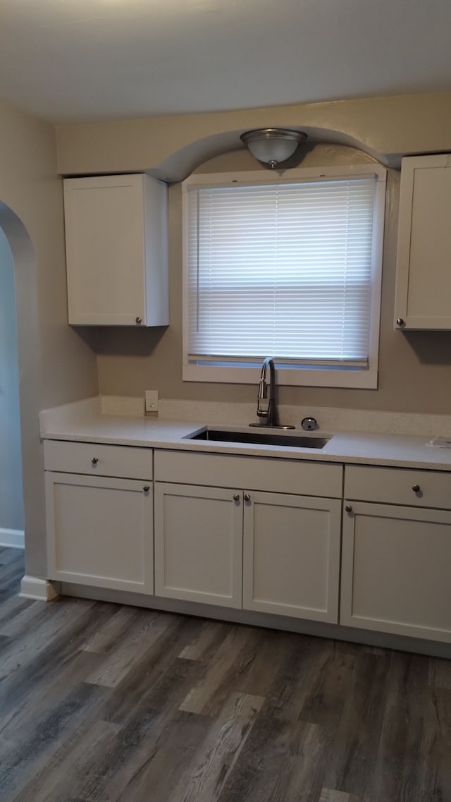 kitchen with white cabinets, sink, and dark wood-type flooring