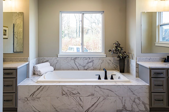 bathroom featuring vanity and a relaxing tiled tub