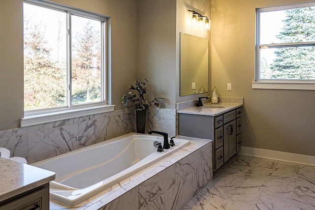 bathroom featuring vanity and tiled bath