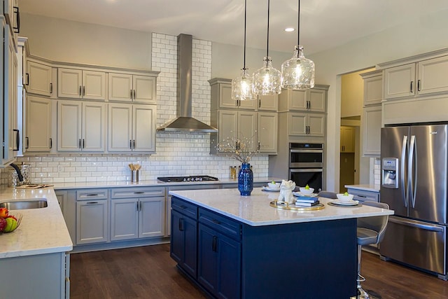 kitchen with wall chimney exhaust hood, stainless steel appliances, sink, a center island, and dark hardwood / wood-style floors