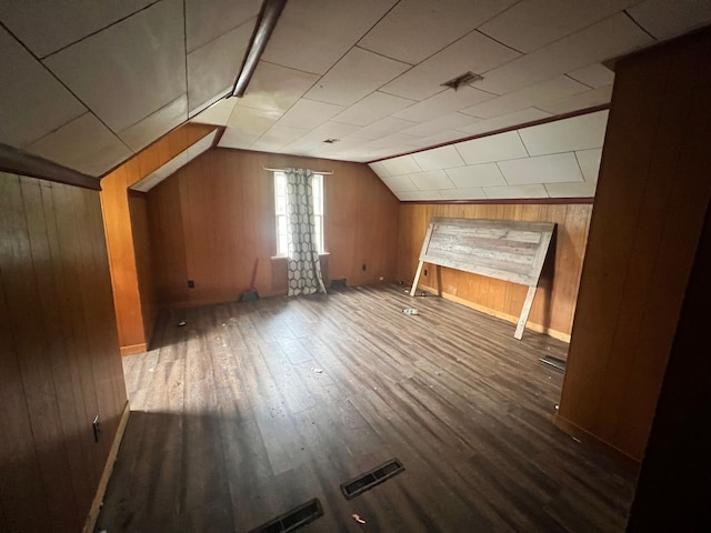 additional living space featuring wooden walls, wood-type flooring, and lofted ceiling