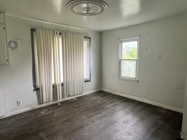 spare room with dark hardwood / wood-style flooring and ceiling fan