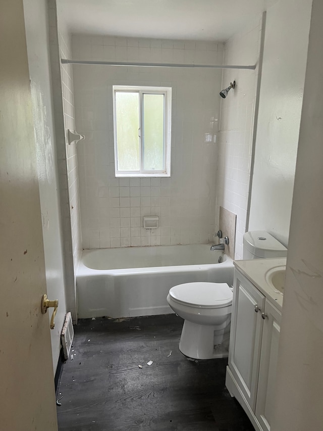 full bathroom featuring vanity, wood-type flooring, tiled shower / bath combo, and toilet