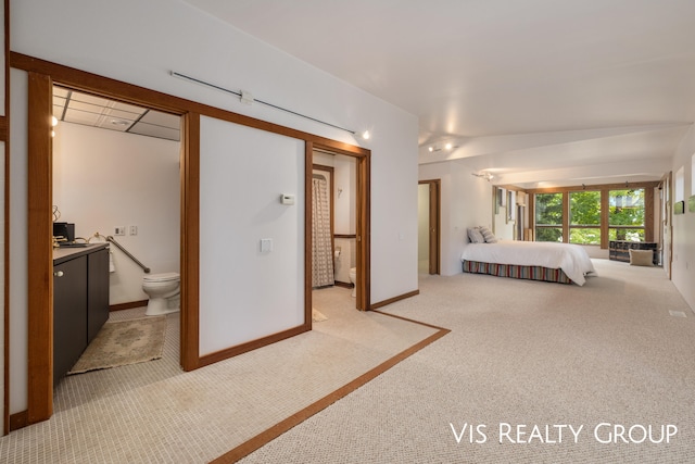 unfurnished bedroom featuring light carpet and connected bathroom