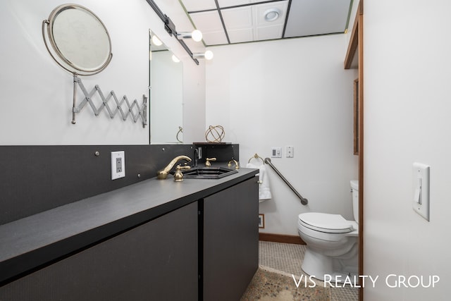 bathroom with tile patterned flooring, vanity, toilet, and backsplash