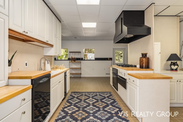 kitchen with a paneled ceiling, white cabinetry, and butcher block counters