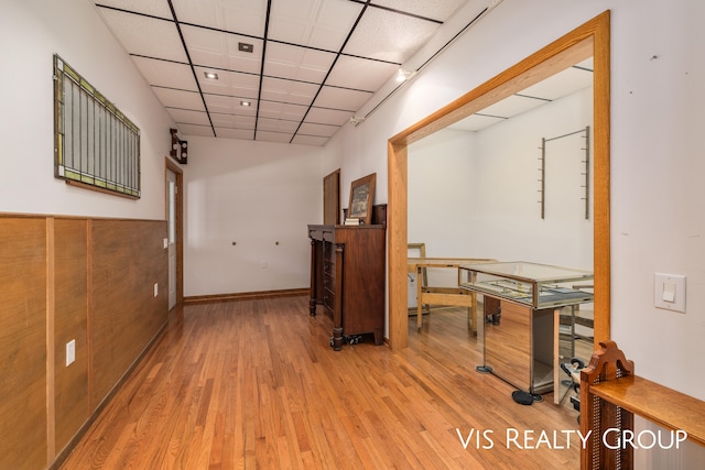 corridor featuring a paneled ceiling and light hardwood / wood-style floors