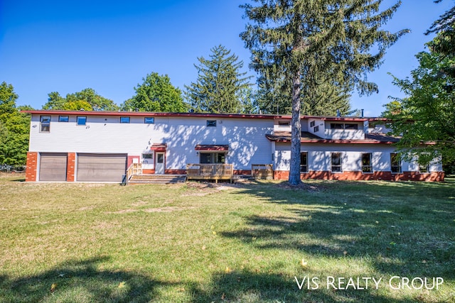 back of property featuring a yard, a deck, and a garage