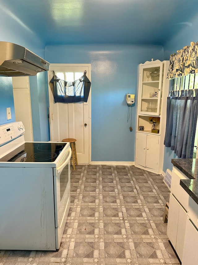 kitchen with white range with electric cooktop, a wealth of natural light, white cabinets, and exhaust hood