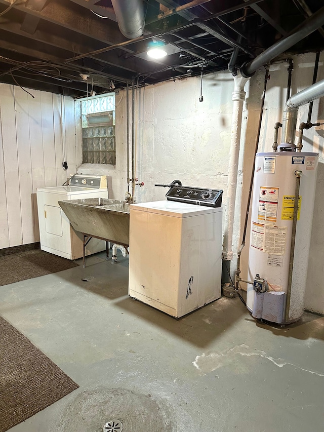 basement featuring water heater, sink, and independent washer and dryer