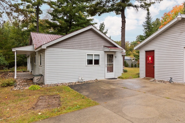 1758 W Nestel Rd, Prudenville, MI 48651 - view of side of property featuring a patio area and metal roof