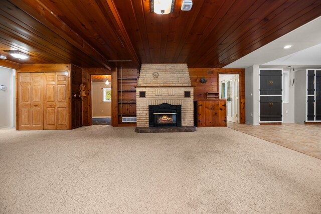 1758 W Nestel Rd, Prudenville, MI 48651 - unfurnished living room with wooden walls, wooden ceiling, a brick fireplace, and carpet flooring
