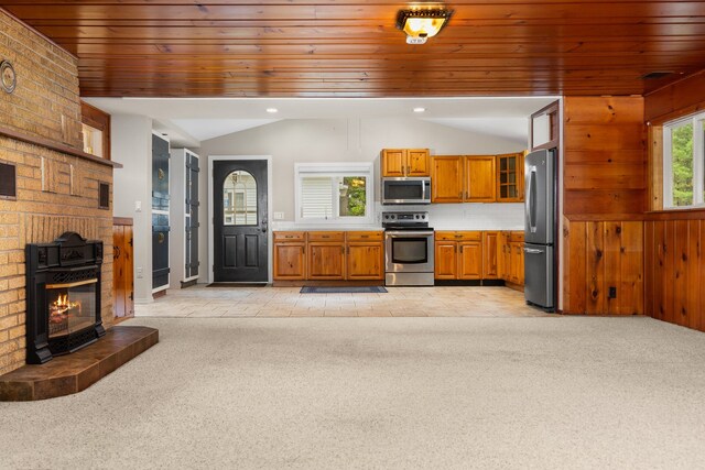1758 W Nestel Rd, Prudenville, MI 48651 - kitchen with stainless steel appliances, brown cabinets, lofted ceiling, light countertops, and light carpet