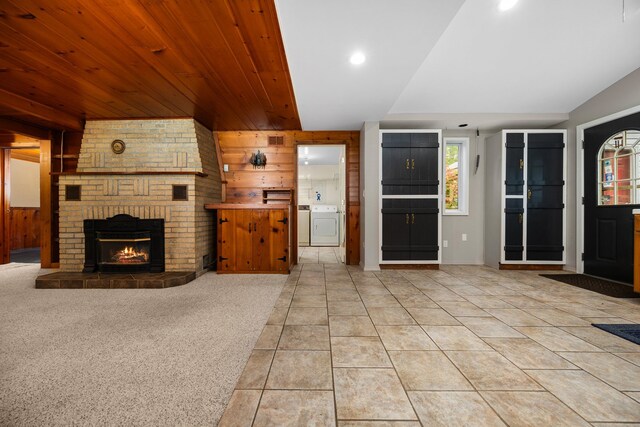 1758 W Nestel Rd, Prudenville, MI 48651 - unfurnished living room with washer / dryer, a brick fireplace, wooden walls, light tile patterned floors, and recessed lighting