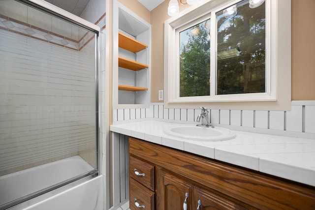 bathroom with vanity and shower / bath combination with glass door