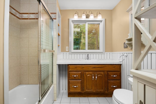 full bathroom featuring tile patterned floors, vanity, bath / shower combo with glass door, and toilet