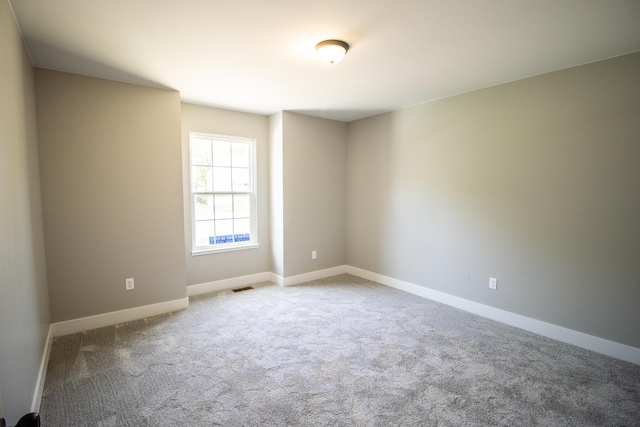 spare room featuring light carpet