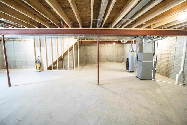 basement with brick wall, heating unit, and water heater