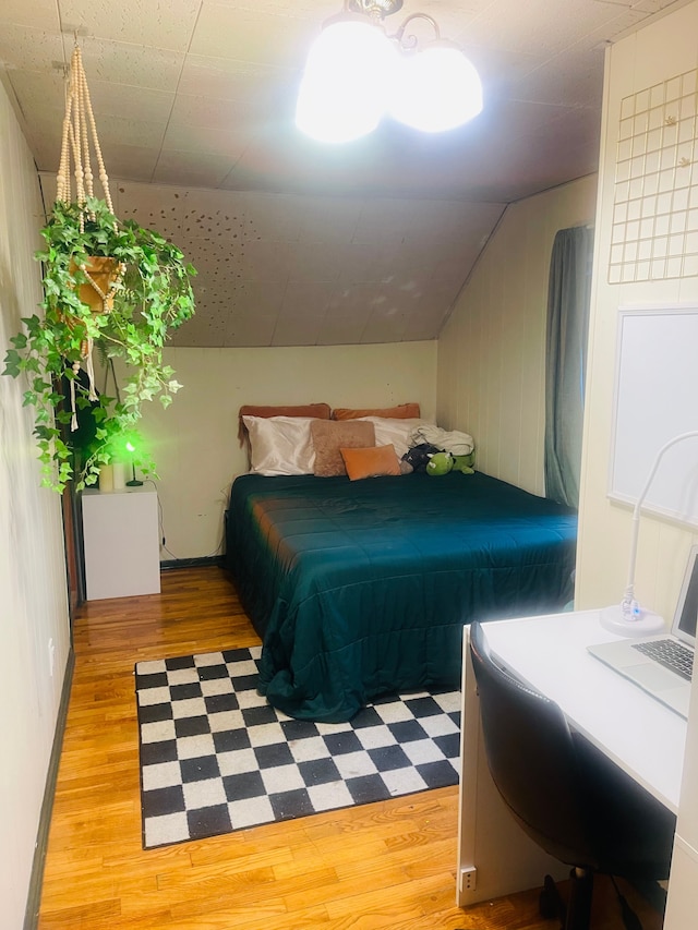 bedroom with vaulted ceiling and light hardwood / wood-style flooring