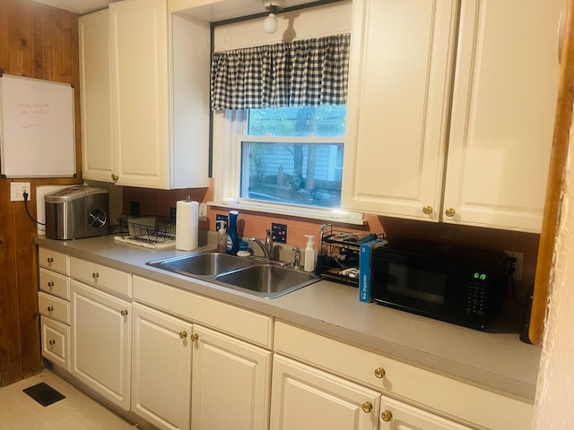 kitchen with white cabinetry, sink, and light tile patterned floors