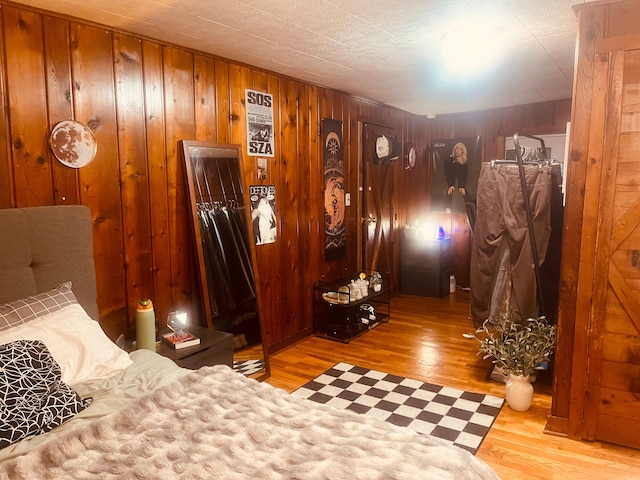 bedroom featuring light wood-type flooring and wood walls