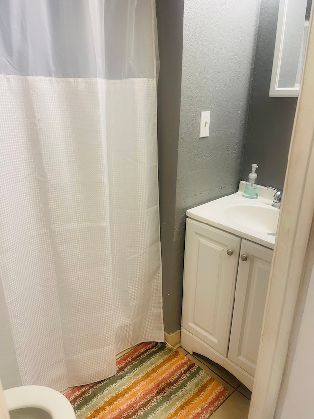 bathroom featuring tile patterned flooring, vanity, and toilet