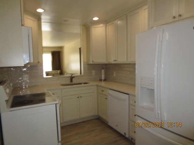 kitchen with white appliances, white cabinets, sink, light wood-type flooring, and tasteful backsplash